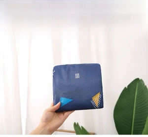 Foldable travel bag detail showing portable size and waterproof navy blue fabric