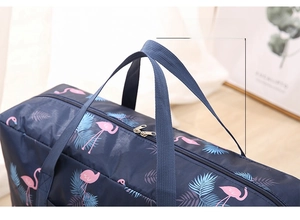 Close-up of reinforced webbing handles and flamingo print on foldable travel bag