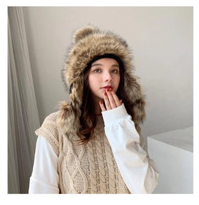Detail view of knitted ushanka hat with faux rabbit fur and fluffy earflap pom-poms