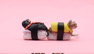 Detail of creative sushi cat charms featuring tuna and tamago toppings on rice base