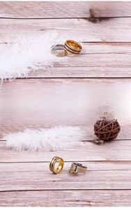 Detail of two-tone stainless steel rings with textured stripes on wooden surface