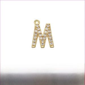 Detailed view of micro-pave cubic zirconia letter M pendant in gold-plated brass