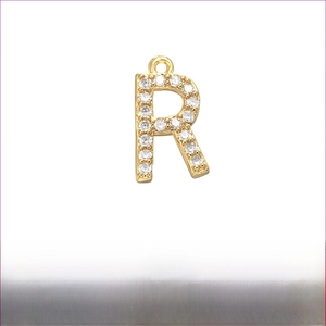 Detail of letter R pendant with micro-pave cubic zirconia in gold plated brass finish