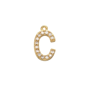 Close-up of gold letter C pendant with micro-pave zircons on a white background