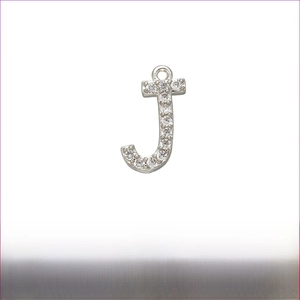 Detailed macro view of silver-tone letter J pendant with micro-paved zircons and brass core
