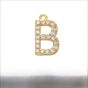 Detail of gold brass letter B pendant with white zircon inlays 12mm by 15mm size