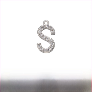Detail of silver-plated letter S pendant with white zircon stones on white background
