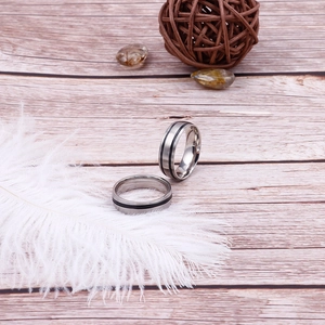 Minimalist titanium steel ring for men with black stripe inlay on a white feather