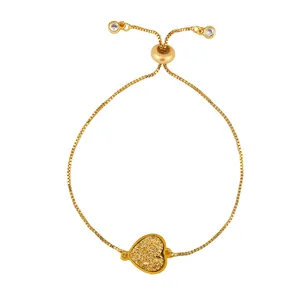 Détail d'un bracelet ajustable en or avec breloque en forme de cœur et fermoir coulissant