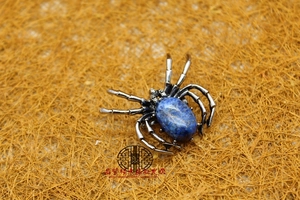 Detailed macro shot of vintage silver spider brooch with blue goldstone oval gem