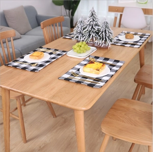 Classic black and white plaid placemat set with golden cutlery on a wooden table
