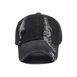 Detailed close-up of distressed denim baseball cap featuring vintage frayed hole design