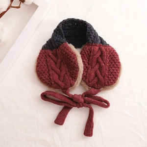 Detail of knit earmuffs with dark red twist texture and soft light brown plush lining