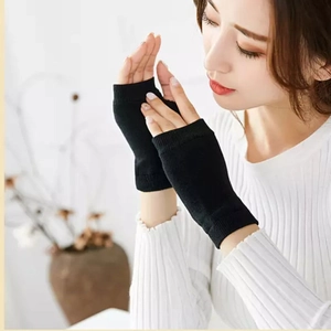 Gros plan de mitaines en tricot noir montrant la texture élastique et le maintien au poignet