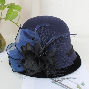 Detail of navy wool felt cloche hat featuring fabric flowers, feathers, and fine mesh veil