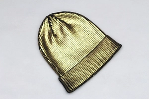 Close-up of metallic gold beanie showing the ribbed knit texture and shiny finish