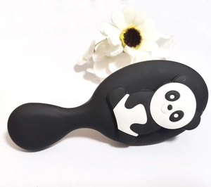 Detail of cute panda cartoon cushion hairbrush with black matte finish and soft bristles