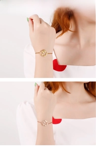 Detailed view of model wearing a world map cutout pendant bracelet in gold and rose gold