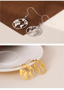 Detail of world map cutout drop earrings in polished silver and gold finishes