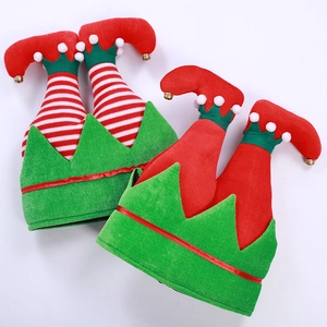 Red and green Christmas elf hats with striped legs and small golden bells on white backdrop