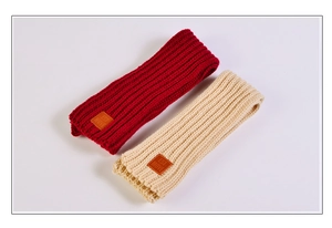Detailed knit texture of red and beige scarves with EST MOVE leather patch detail