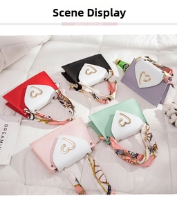 Flat lay of small crossbody bags with heart-shaped closures and scarf-wrapped handles