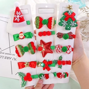 Close-up of Christmas hair clips featuring reindeer, Santas, and festive velvet bows