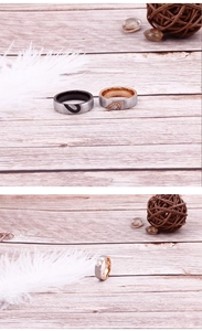 Close-up of brushed titanium heart couple rings with crystals on light wood surface