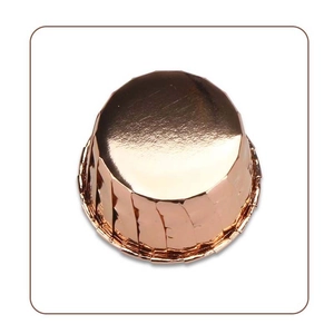 Vue détaillée de moules à cupcakes en or rose avec bords plissés en métal thermorésistant
