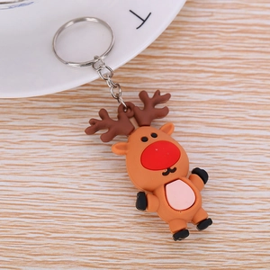 Detail of a brown reindeer cartoon keychain made of soft silicone on a wood background