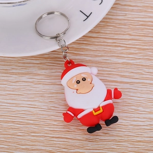 Flat lay of Santa Claus PVC keychain with metal ring on light wood texture background