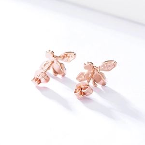 Macro detail of rose gold bee stud earrings with sparkling crystals and butterfly backs