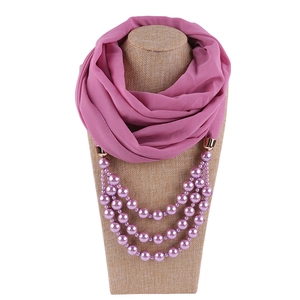 Detailansicht von rosa Chiffonschal mit dreilagiger Perlenkette auf einer Schaufensterpuppe