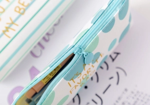 Detailed close-up of blue canvas pencil case zipper with striped and polka dot patterns