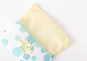 Detail of canvas pencil case with gold lettering and waterproof yellow lining interior