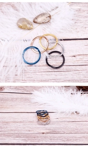 Close-up of minimalist stainless steel rings in assorted colors and heart shapes