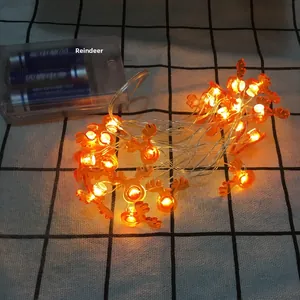 Detail of warm glow LED reindeer string lights with clear battery box on a checkered background