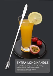 Detail of long-handle stainless steel mixing spoon next to a tall glass with fresh fruit