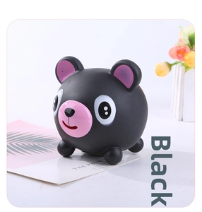 Detail view of a black bear squeeze toy with pink ears on a clean decorative table