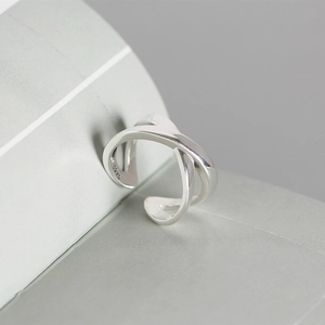 Macro shot of silver S925 sterling silver ring showing polished crisscross band design