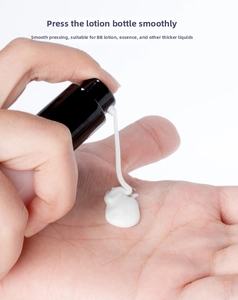 Macro view of a black pump bottle dispensing smooth white cream texture on white background
