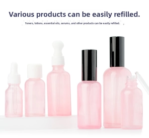 Detailed view of pink translucent glass cosmetic bottles with various pump and dropper heads