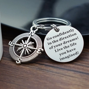 Silver metal keychain with compass pendant and inspirational engraved quote charm