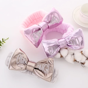 Soft plush bow headbands in pink purple and grey featuring shiny OMG! letter prints