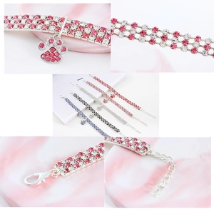 Macro detail of elastic pet collar showing paw print pendant and sparkling rhinestones
