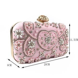 Detail view of pink satin evening clutch with handmade pearl and rhinestone floral embroidery