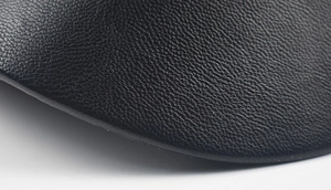 Close-up of black lychee grain PU leather texture on a stylish newsboy beret hat