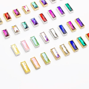 Macro view of colorful faceted glass nail gems with gold and silver metal base frames