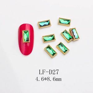 Macro detail of LF-D27 emerald rectangular nail charm with gold rim and 4.6x8.6mm size