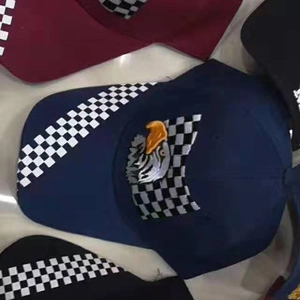 Top view of eagle and racing flag embroidered baseball caps in navy, burgundy, and black